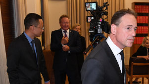 Health minister Greg Hunt walks away from Chinese consul-general Zhou Long and Andrew Forrest after the press conference.