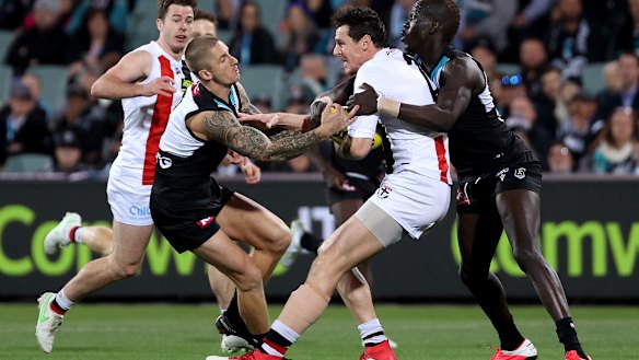 Hamish Hartlett, left, and Aliir Aliir, right, tackle Jake Carlisle.