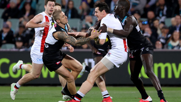 Hamish Hartlett, left, and Aliir Aliir, right, tackle Jake Carlisle.