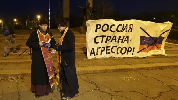 Two Ukrainian Orthodox priests stand next to a banner reading "no blockade of the Azov Sea!" during a rally in Mariupol, south coast of Azov sea, eastern Ukraine.