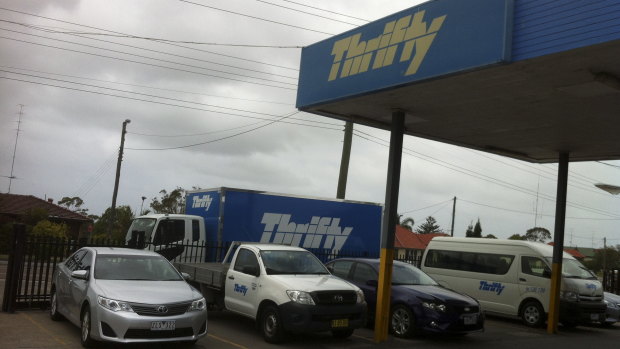 A Thrifty car rental depot with a range of vehicles for hire.