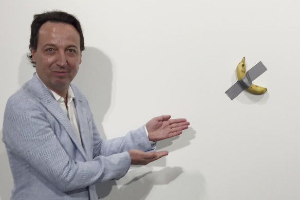 Gallery owner Emmanuel Perrotin next to Maurizio Cattelan's 'Comedian', prior to its consumption.