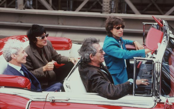 Traffic stoppers: Charlie Watts, in the foreground in the back seat, with his Rolling Stones bandmates, Mick Jagger, driving, Keith Richards, in the front passenger seat, and Ron Wood  on the Brooklyn Bridge in August 1997, on their way to a news conference to announce the start of their “Bridges to Babylon” world tour. 