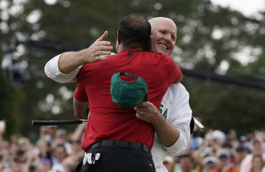 Tiger Woods hugs his Joe LaCava after sinking his final putt on the 18th.