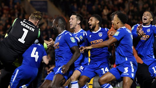 Bedlam: Colchester United's Tom Lapslie (4) is mobbed by teammates after scoring the winning penalty against Tottenham Hotspur at JobServe Community Stadium in Colchester.