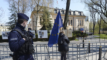 A woman holds a European Union flag outside the Constitutional Tribunal, background in Warsaw.