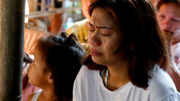 The mother of the slain girl Myka Ulpina cries during mass at her wake.