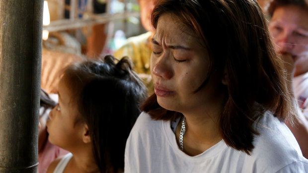 The mother of the slain girl Myka Ulpina cries during mass at her wake.