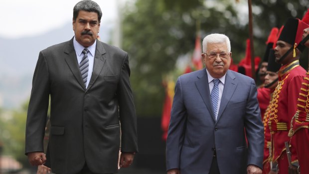 President Nicolas Maduro, left, walks with Palestinian President Mahmud Abbas as they review the honour guard during a welcoming ceremony in Caracas, Venezuela, on Monday.