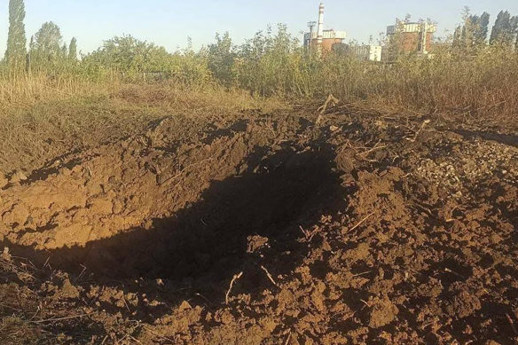 A crater left by a Russian rocket is 300 metres from the South Ukraine nuclear power plant, in the background, close to Yuzhnoukrainsk, in the Mykolayiv region of Ukraine.