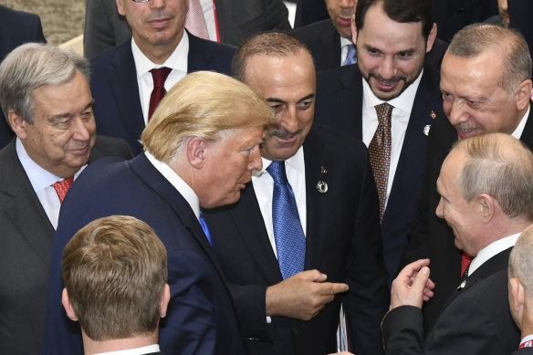 In this file picture from the sidelines of June 2019 G20 summit, US President Donald Trump (centre left) talks with Russian President Vladimir Putin (centre right) as Turkey's President Recep Tayyip Erdogan (right) and United Nations Secretary-General Antonio Guterres (left) look on.