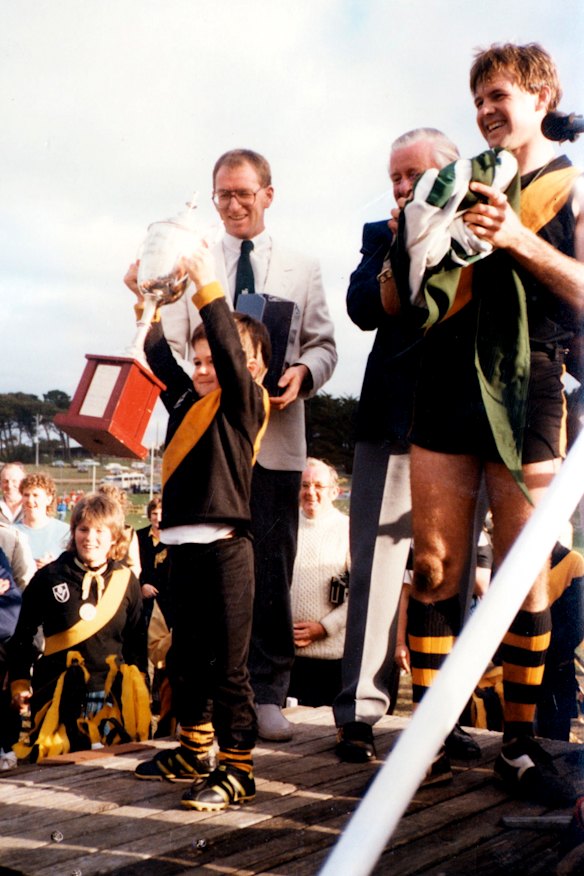 Jonathan Brown, aged 3, raises the premiership cup after his father, Brian, captain-coached Colac-Coragulac to the 1985 flag.