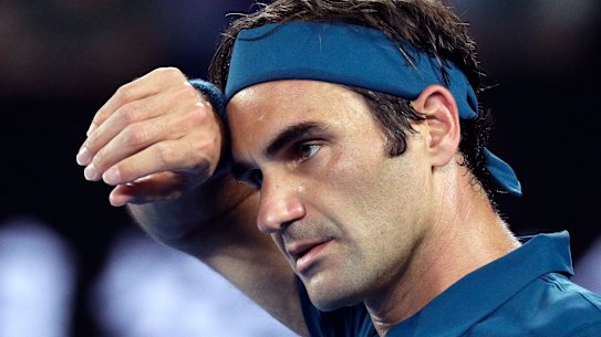 Switzerland's Roger Federer wipes the sweat from his face during his third round match against United States' Taylor Fritz at the Australian Open tennis championships in Melbourne, Australia, Friday, Jan. 18, 2019. (AP Photo/Kin Cheung)