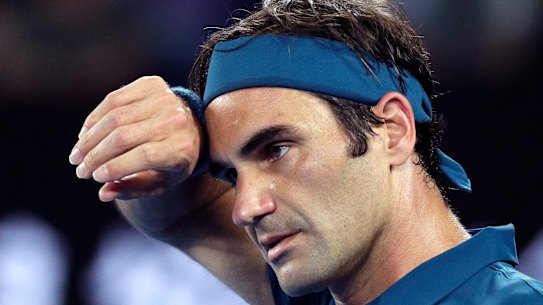 Switzerland's Roger Federer wipes the sweat from his face during his third round match against United States' Taylor Fritz at the Australian Open tennis championships in Melbourne, Australia, Friday, Jan. 18, 2019. (AP Photo/Kin Cheung)