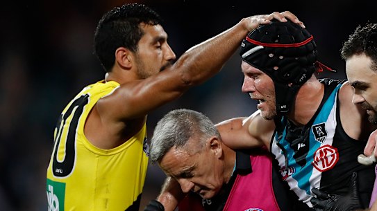 Richmond's Marlion Pickett acknowledges Port's Brad Ebert as the Power veteran leaves the field with concussion.