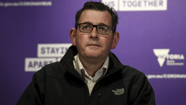 Victorian Premier Daniel Andrews in front of the Staying Apart Keeps Us Together slogan. 