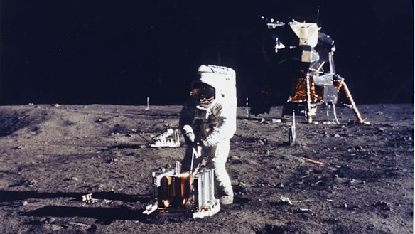 Buzz Aldrin deploys an experiment on the surface of the moon.