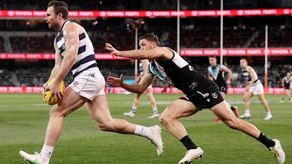 A lunging Travis Boak in pursuit of Cat Patrick Dangerfield in the qualifying final between Port Adelaide and Geelong.