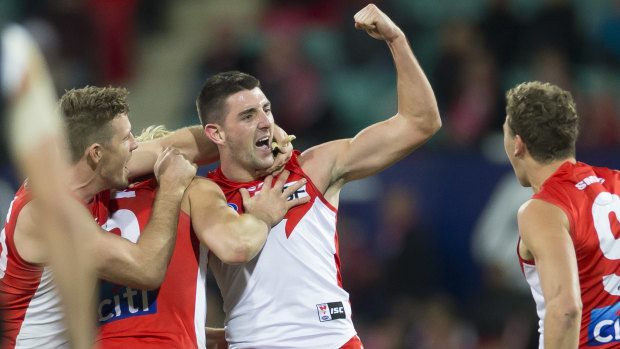 Cheer, cheer: The Swans celebrate Colin O’Riordan’s first AFL goal during a drought-breaking win on Friday night.