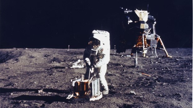Buzz Aldrin deploys an experiment on the surface of the moon.