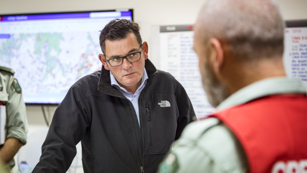 Premier Daniel Andrews is briefed by emergency services personnel. 