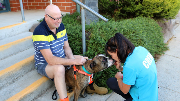 New owner Bill Peisley watches on as Cooper says goodbye to staff at the RSPCA ACT shelter in Weston on Friday.