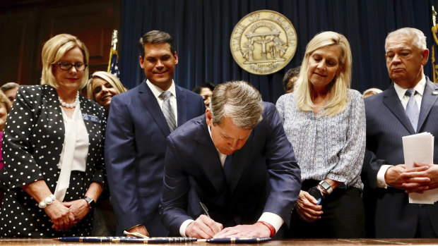 Georgia’s Republican Governor Brian Kemp signs legislation on Tuesday.