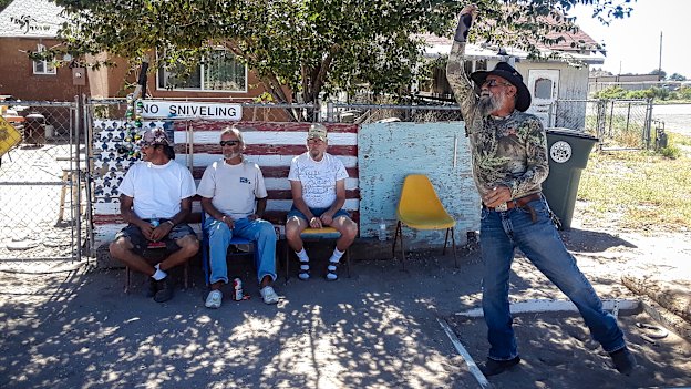 Eloy Valdez tosses a horsehoe watched by David Warne (centre on bench) and friends.