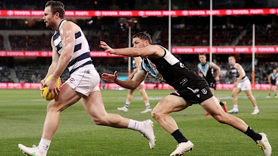 A lunging Travis Boak in pursuit of Cat Patrick Dangerfield in the qualifying final between Port Adelaide and Geelong.