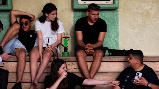 Israeli youths without face masks enjoy a sunny day at Tel Aviv’s beach, Israel, on Sunday, April 18.