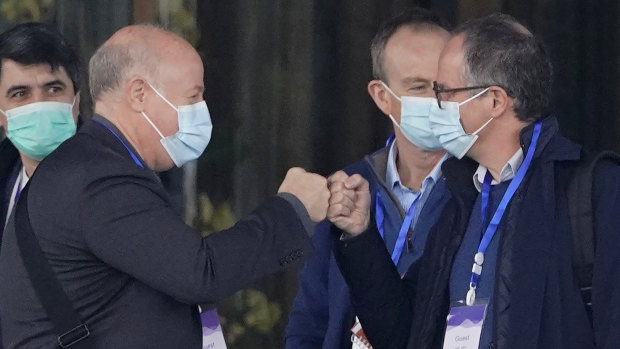 WHO investigator Peter Daszak, left, bumps fists with Peter Ben Embarek during their field visit in Wuhan.