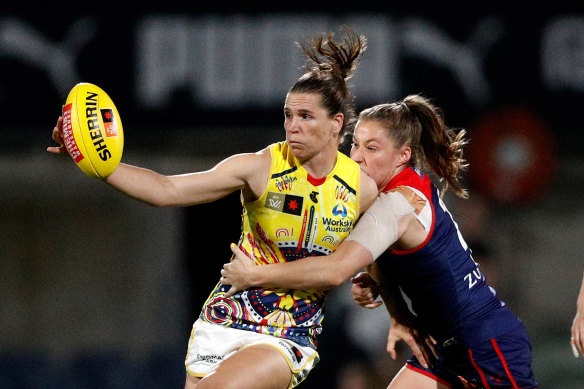 Adelaide skipper Chelsea Randall feels the force of Demons midfielder Olivia Purcell.