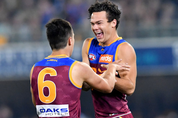 Hugh McCluggage (left) of the Lions celebrates kicking a goal with Cam Rayner (right). 