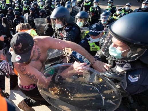 Police clash with protestors at the Shrine on Wednesday. The occupation of the shirtless gentleman is unknown, although we note he is wearing Tradie underwear. Sadly, his refreshing can of Wild Boar bourbon and cola appears to have been collateral damage in the fracas.