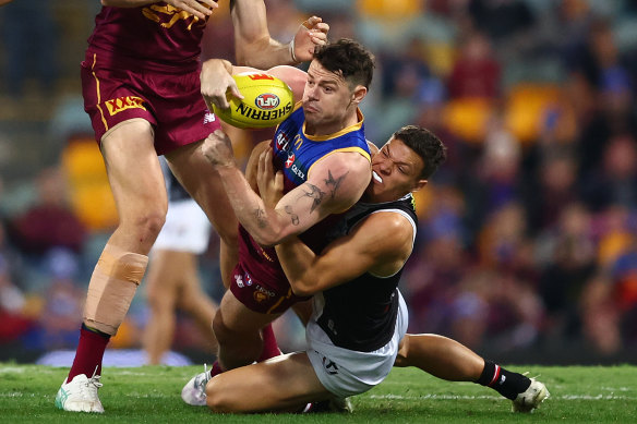 Lachie Neale of the Lions handballs.