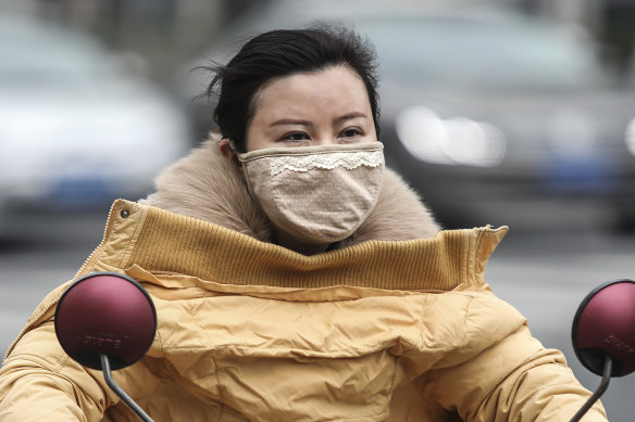 A woman wears a mask in Wuhan, which has been linked to cases of the new coronavirus.