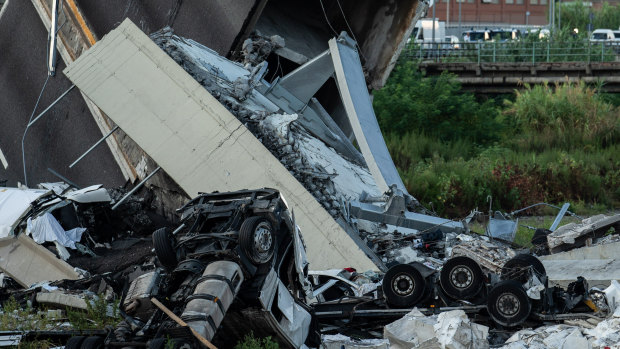 Chassis of vehicles and rubble from the Morandi Bridge sit on the ground after the collapse.