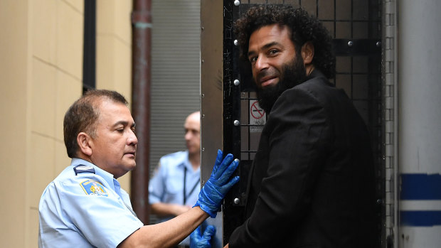 Gazi Safarjalani is escorted from a transport vehicle at the Supreme Court in Sydney on Friday.