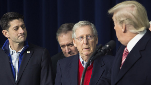 Senate Majority Leader Mitch McConnell, a Republican from Kentucky, centre, and US House Speaker Paul Ryan, a Republican from Wisconsin, left, listen as US President Donald Trump.