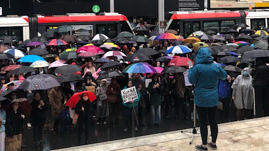 Rallygoers listen to a speaker at the steps of Sydney Town Hall in July.