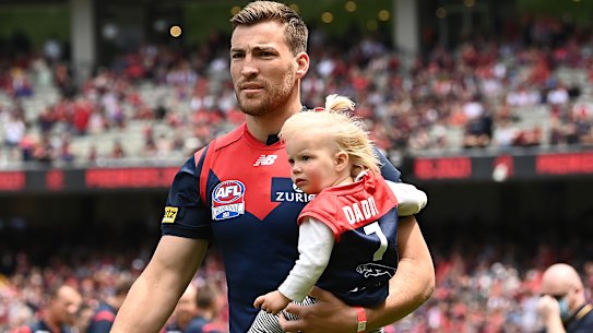 Jack Viney, holding his daughter, walks out on to the MCG as a premiership player.