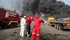 Firefighters work as black smoke rises in the sky after a massive explosion rocked a port near the southern city of Bandar Abbas, Iran.