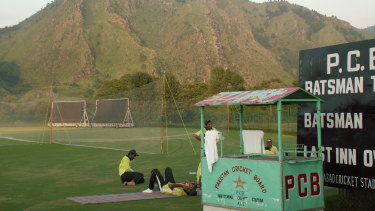 Pakistan players relax after a training session at the Abbottabad cricket ground at Kakul with the Shimla Hills in the background.
