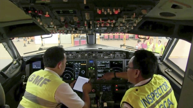 Investigators inspect the cockpit of a Boeing 737 MAX 8 aircraft in hangar in Indonesia.