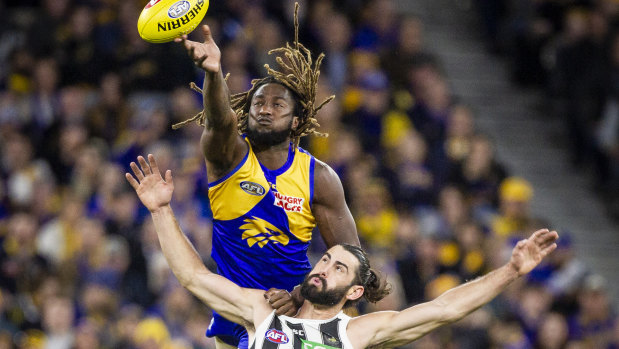 Eagle Nic Naitanui soars over Brodie Grundy at Optus Stadium.