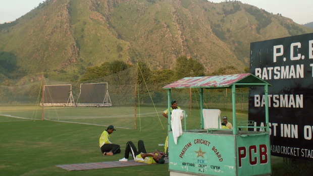 Pakistan players relax after a training session at the Abbottabad cricket ground at Kakul with the Shimla Hills in the background.