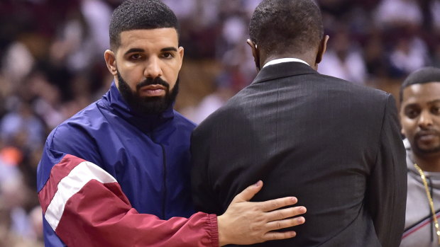 Canadian rapper Drake pats Raptors coach Dwane Casey on the back during game two against Cleveland.
