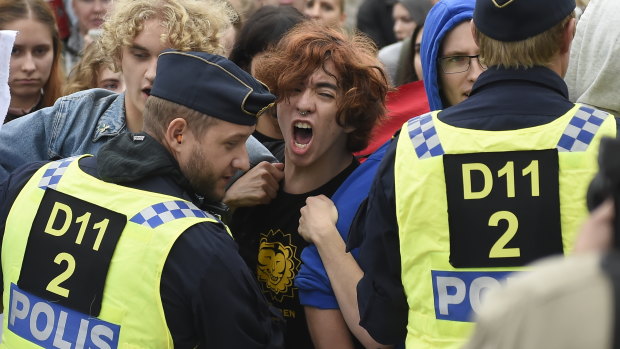 Police push back people protesting a far-right "Alternative For Sweden" campaign meeting in Kungstradgarden park in Stockholm on Friday.