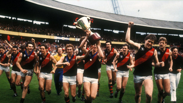 Mark Harvey, the youngest Bomber in the team, carries the premiership cup.