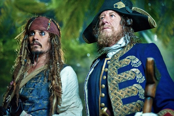Geoffrey Rush como Hector Barbossa ao lado de Johnny Depp em Piratas do Caribe.